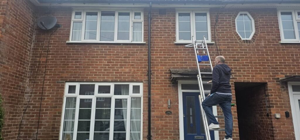Gutter being cleared of moss and debris in Hertfordshire